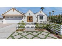 Charming white brick home with a well-manicured front yard and a white picket fence at 542 E Hayward Ave, Phoenix, AZ 85020