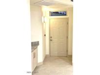 Neutral entryway features a white front door and cabinet with light grey stone countertop at 8653 E Royal Palm Rd # 1006, Scottsdale, AZ 85258