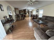 Inviting living room with wood floors, comfortable seating, open layout to kitchen and dining area at 9828 E Pueblo Ave # 67, Mesa, AZ 85208