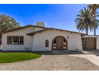 Charming home featuring an arched entryway, low-maintenance landscaping, and a tan stucco exterior with a detached garage at 113 W Rawhide Ave, Gilbert, AZ 85233