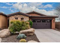 Charming home featuring a stone facade, desert landscaping, and a two-car garage at 12129 W Desert Mirage Dr, Peoria, AZ 85383