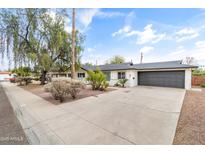 Charming single-story home featuring a spacious driveway, mature trees, and a well-maintained landscape at 1509 W Tuckey Ln, Phoenix, AZ 85015