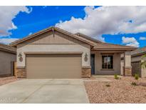 Charming single-story home featuring a two-car garage and neutral-toned exterior with stone accents at 16972 W Fetlock Trl, Surprise, AZ 85387