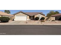 Cozy single-story home with desert landscaping, a two-car garage, and a neatly maintained front yard at 2142 E Wildhorse Dr, Chandler, AZ 85286