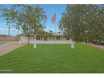 Charming single-story home featuring a well-manicured lawn and a prominent American flag at 3333 N 81St Ave, Phoenix, AZ 85033