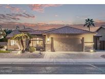 Inviting home showcases the desert landscaping, stylish garage doors, and beautiful sunset at 3544 N 149Th Ave, Goodyear, AZ 85395