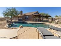 Private backyard oasis featuring sparkling pool with rock waterfall and a covered patio at 3720 E Vista Grande --, San Tan Valley, AZ 85140