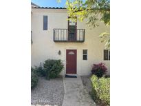 Charming home featuring a red front door, balcony, and desert landscaping, providing a welcoming curb appeal at 4818 N 73Rd St, Scottsdale, AZ 85251