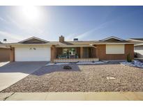 Charming single-story home featuring a well-maintained front yard with desert landscaping and a covered porch at 518 S Racine --, Mesa, AZ 85206