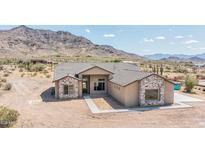 Stunning single-story home with stone accents and desert landscaping against a backdrop of picturesque mountains at 6107 E Lone Mountain Rd, Cave Creek, AZ 85331