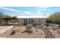 Charming single-story home featuring a white metal roof, desert landscaping, and a covered parking area at 6107 E Lone Mountain Rd, Cave Creek, AZ 85331