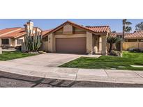 Charming single-story home featuring a two-car garage and desert landscaping at 9803 N 100Th Pl, Scottsdale, AZ 85258