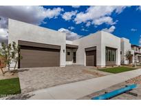 Contemporary home featuring a three car garage and a well-manicured lawn at 10308 E Utah Ave, Mesa, AZ 85212
