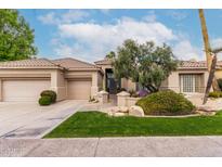 Charming single-story home featuring a well-maintained lawn, desert landscaping and a three car garage at 11664 E Del Timbre Dr, Scottsdale, AZ 85259