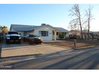 Charming single-story home with desert landscaping and a concrete driveway and two large vehicles parked there at 1253 E Avila Ave, Casa Grande, AZ 85122