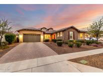 Beautiful home featuring stone and stucco exterior, two-car garage, and lush landscaping at 14845 W Georgia Dr, Surprise, AZ 85379
