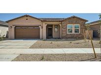 Charming single-story home with a two car garage and low maintenance desert landscaping in the front yard at 15053 W Gray Fox Trl, Surprise, AZ 85387
