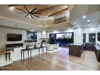 Beautiful living room featuring wood beam ceiling, fireplace and large windows, seamlessly opening to the pool area at 22500 N 97Th St, Scottsdale, AZ 85255