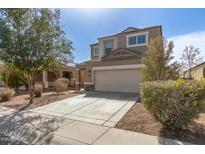 Inviting two-story home with a well-maintained lawn, desert landscaping, and attached two-car garage at 29991 W Mitchell Ave, Buckeye, AZ 85396