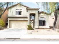 Two-story home with a two-car garage, arched entryway, desert landscaping, and covered front porch at 896 E Dragon Fly Rd, San Tan Valley, AZ 85143