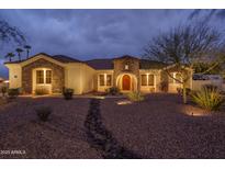 Charming single-story home featuring a stone facade, manicured desert landscaping, and a welcoming entrance at 9612 W Mariposa Grande --, Peoria, AZ 85383