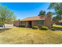 Charming single-story home with mature landscaping, inviting entry and tan exterior paint at 107 Leisure World --, Mesa, AZ 85206