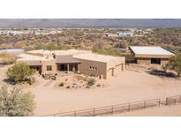 Expansive front exterior view of a desert home featuring a tile roof, natural landscaping, and a three-car garage at 16835 E Skinner Dr, Rio Verde, AZ 85263