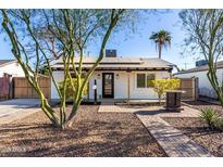 Charming single-story home with a brick pathway, complemented by mature landscaping and a well-maintained front yard at 2205 N 22Nd St, Phoenix, AZ 85006