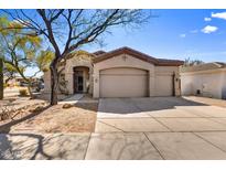 Charming single-story home with a three car garage, desert landscaping, and a well-manicured lawn at 22503 N 76Th Pl, Scottsdale, AZ 85255