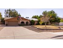 Charming single-story home featuring a well-manicured front yard, arched entryway and solar panels at 3419 E Cholla St, Phoenix, AZ 85028