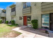 Inviting exterior view of a two-story home with a well-maintained lawn and desert landscaping at 4610 N 68Th St # 402, Scottsdale, AZ 85251