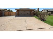Long driveway leading to a two-car garage with brick accents and a privacy gate at 6431 W Monte Cristo Ave, Glendale, AZ 85306