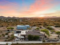 Expansive property featuring a pool, patio, and multiple buildings under a vibrant sunset sky at 103 W Tanya Rd, Phoenix, AZ 85086