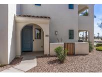 Charming front entrance with a light blue door, an arched entryway, and low maintenance desert landscaping at 14200 W Village Pkwy # 107, Litchfield Park, AZ 85340