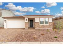 Charming single-story home featuring stone accents, a two-car garage, and low maintenance desert landscaping at 16804 W Yucatan Dr, Surprise, AZ 85388