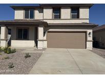 Two-story home with a two car garage and a well maintained front yard and desert landscaping at 16954 W Molly Ln, Surprise, AZ 85387