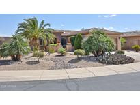 Attractive desert landscaping accents this tan home with a tile roof at 19437 N Guardian Ln, Surprise, AZ 85387