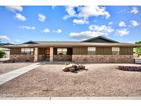 Charming single-story home showcasing a well-kept exterior with beautiful brick accents and mature landscaping at 2205 E Fox St, Mesa, AZ 85213