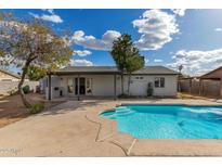 Backyard pool with spacious concrete deck and covered patio is ready for entertaining at 4026 E Captain Dreyfus Ave, Phoenix, AZ 85032