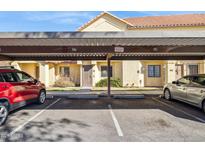 View of covered parking and the front of the building with desert landscaping at 455 S Mesa Dr # 126, Mesa, AZ 85210