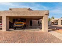 View of the home's exterior with a covered parking area and a yellow Ford Bronco at 6159 E Indian School Rd # 110, Scottsdale, AZ 85251