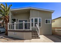 Charming exterior featuring a well-maintained yard, a covered porch with white railings, and mature landscaping at 632 Aero Rd, Mesa, AZ 85205