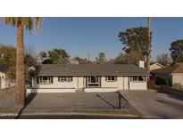 Charming single-story home featuring desert landscaping, a grey roof, and modern black accents on a bright sunny day at 7819 N 17Th Ave, Phoenix, AZ 85021