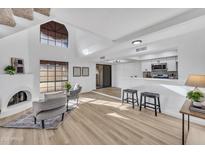 Bright living room features high ceilings, a fireplace, modern seating, and an open layout at 8840 S 51St St # 2, Phoenix, AZ 85044