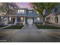 Inviting two-story home featuring a porte-cochere, desert landscaping, and a welcoming front porch at 12956 N 152Nd Ave, Surprise, AZ 85379