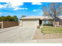Charming single-story home with a two-car garage, desert landscaping, and a well-maintained lawn at 14398 W Marcus Dr, Surprise, AZ 85374