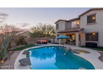 Backyard oasis featuring a sparkling blue pool, spa, and comfortable seating area perfect for entertaining at 18413 W Paseo Way, Goodyear, AZ 85338
