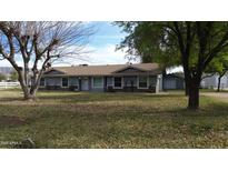 Charming single-story home featuring a well-maintained lawn and lush trees creating a serene curb appeal at 4311 W Siesta Way, Laveen, AZ 85339
