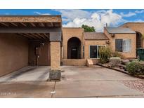 Charming stucco home featuring a covered carport and an arched entryway at 5142 E Holly St, Phoenix, AZ 85008