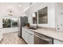Modern kitchen featuring stainless steel appliances, granite countertops, and white cabinetry at 5142 E Holly St, Phoenix, AZ 85008